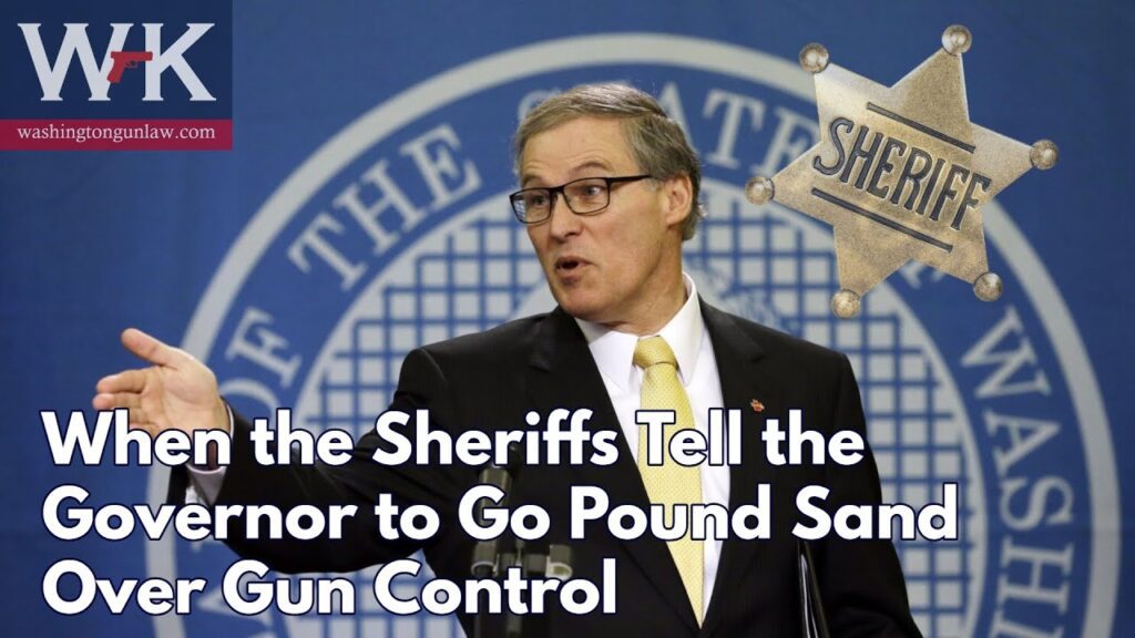 A man in a suit speaks at a podium with a large blue backdrop featuring a circular design. Text on the image reads, "When the Sheriffs Tell the Governor to Go Pound Sand Over Gun Control," alongside a sheriff's badge graphic.
