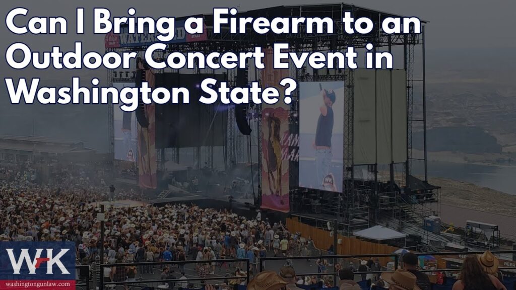 Outdoor concert with a large crowd in front of a stage. The screen displays the text "Can I Bring a Firearm to an Outdoor Concert Event in Washington State?" Several people are wearing cowboy hats. Mountains are visible in the background.