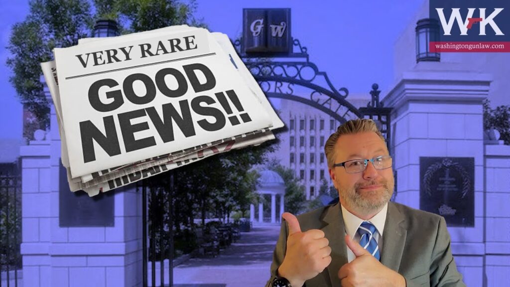 A man in a suit gives a thumbs-up in front of a backdrop featuring a large newspaper headline reading "Very Rare Good News!!" The background shows a gated entrance to a building, and a logo with "WK" is in the top right corner.