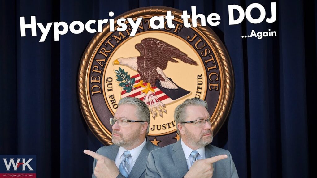 Two identical men in suits point in opposite directions in front of a Department of Justice seal. Text above them reads, "Hypocrisy at the DOJ ...Again." A logo with "WK" is in the bottom left corner.