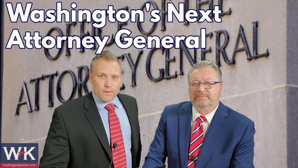 Two men in suits stand in front of a wall with "Office of the Attorney General" written on it. The text above them reads "Washington's Next Attorney General." Both are wearing glasses and ties.