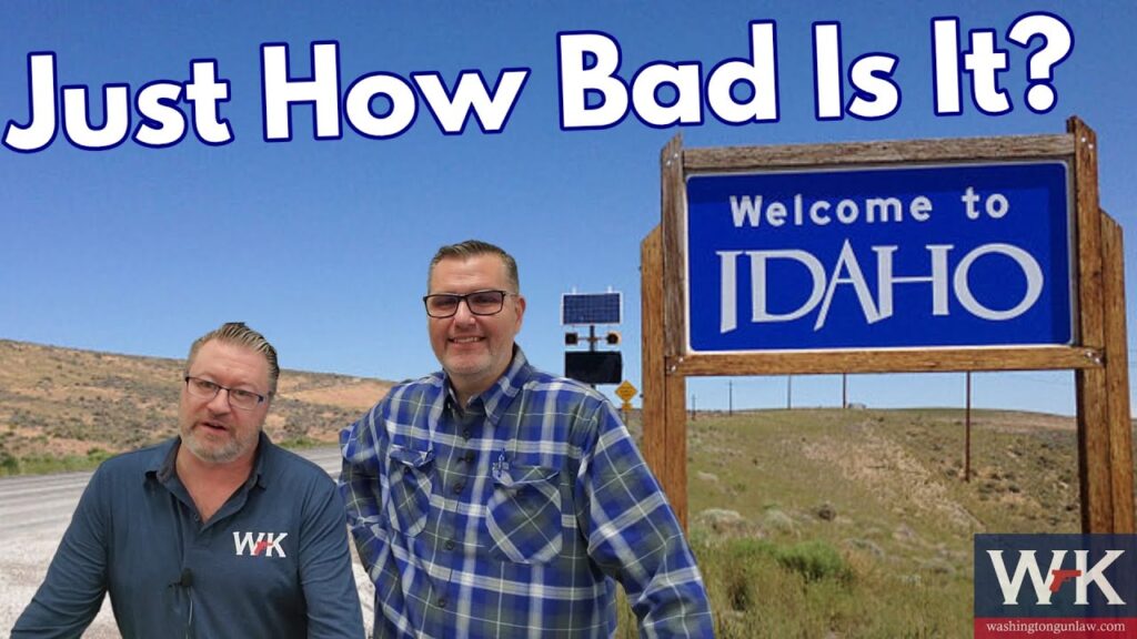 Two men are standing on a roadside next to a "Welcome to Idaho" sign. One man wears a blue plaid shirt and glasses; the other wears a dark collared shirt. The text above them reads, "Just How Bad Is It?" with a landscape of hills in the background.