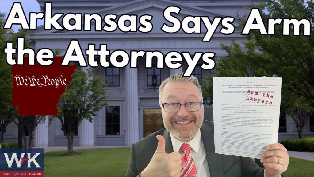 A man in a suit holds up a document with "Arm the Lawyers" written on it, smiling and giving a thumbs-up outside a courthouse. The text reads, "Arkansas Says Arm the Attorneys.