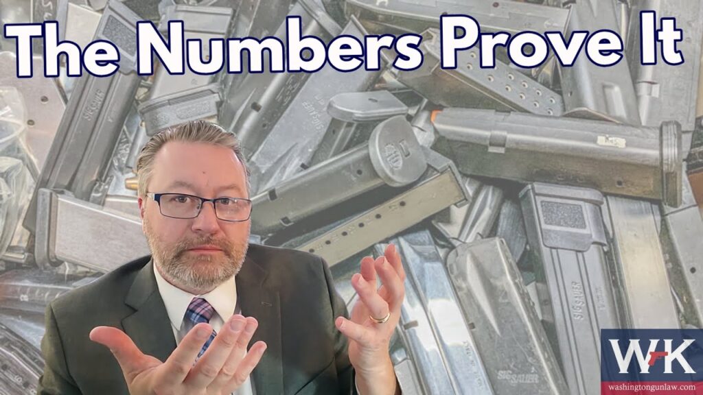 A man in a suit gestures with his hands in front of a background filled with gun magazines. The text "The Numbers Prove It" appears at the top, and there's a red and blue logo in the bottom right corner.