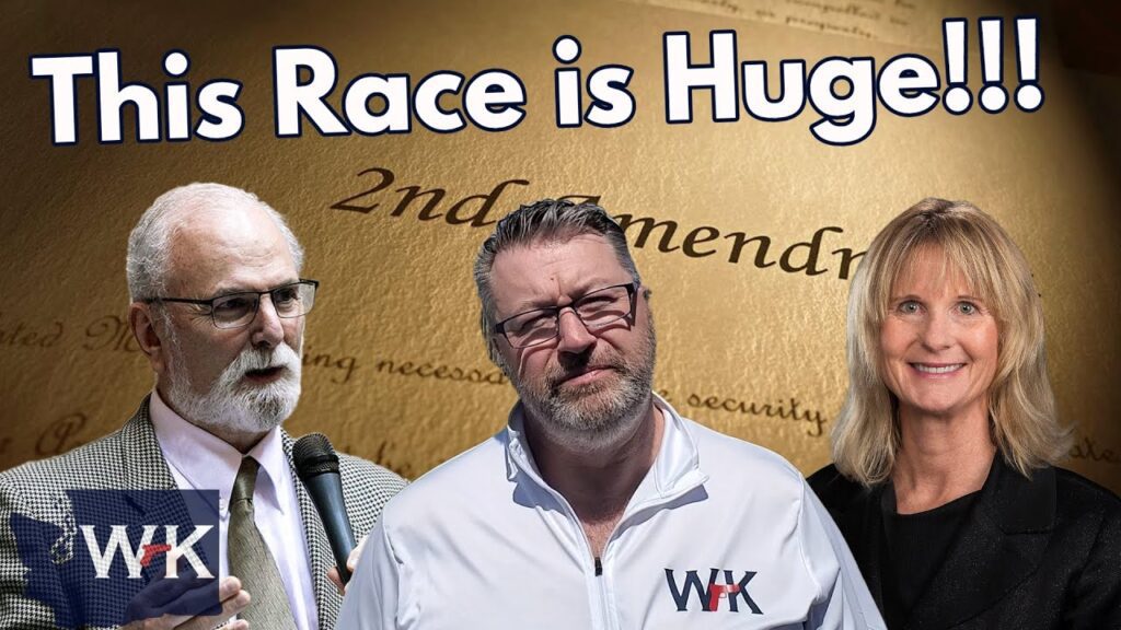 Three individuals are in front of a document titled "2nd Amendment." Large text above reads, "This Race is Huge!!!" One man holds a microphone; another wears a white jacket. A woman is smiling. The WHK logo appears in the lower left corner.