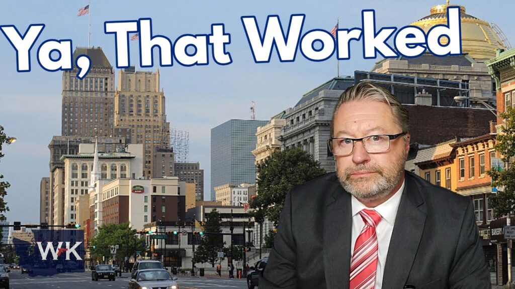 A man in a suit and tie is in the foreground with a cityscape in the background. The text "Ya, That Worked" is displayed above. The WK logo is in the bottom left corner.