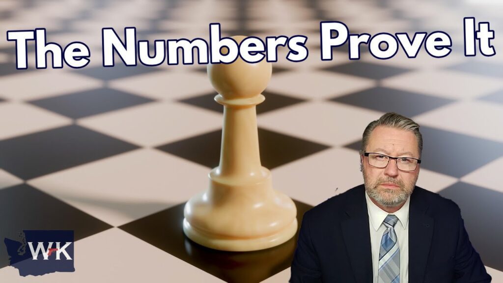 A large chess pawn stands on a chessboard with the text "The Numbers Prove It" above. A man in a suit and tie is positioned in the lower right corner. A logo with "W K" is in the bottom left corner. The background is blurred.