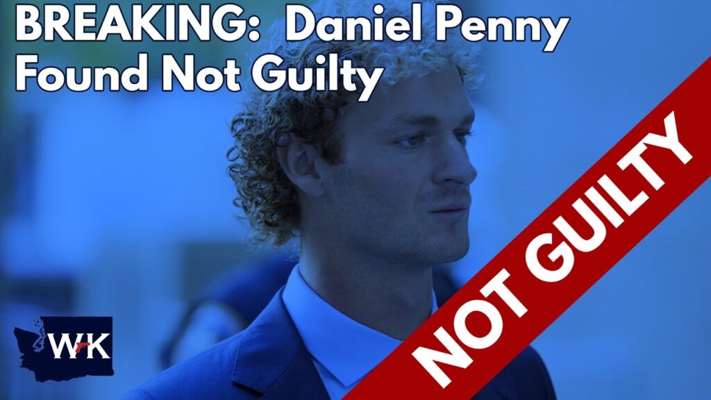 Blue-tinted image of a man with curly hair in a suit. Text overlay reads "BREAKING: Daniel Penny Found Not Guilty" with a red diagonal banner stating "NOT GUILTY." There's a small WK logo in the corner.