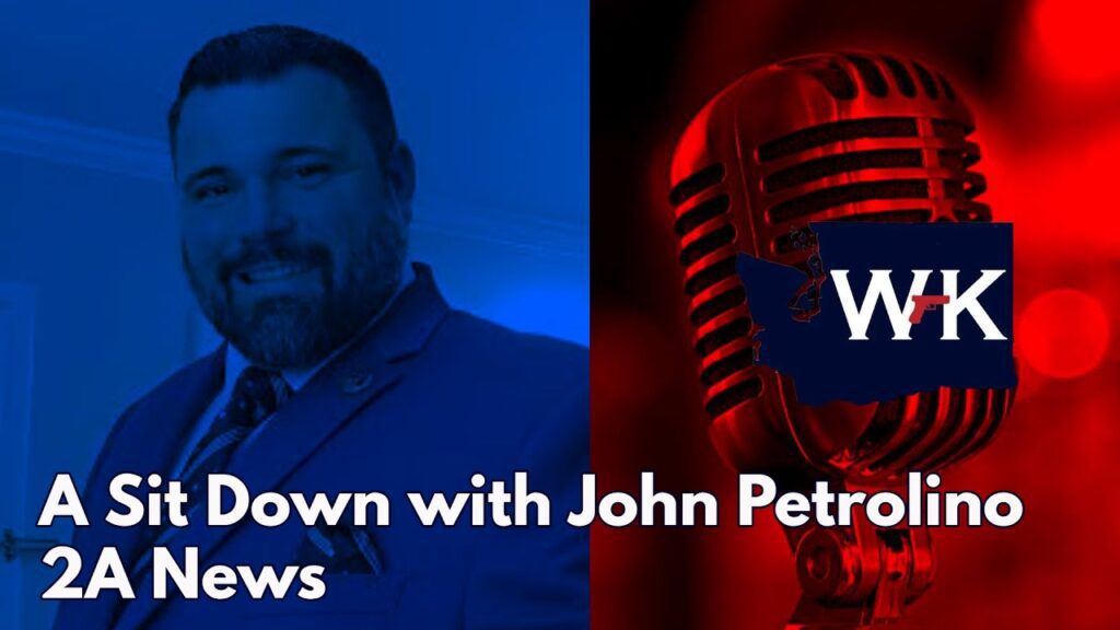 Blue and red split image featuring a man in a suit on the left and a retro microphone on the right. Text reads, "A Sit Down with John Petrolino 2A News" over a graphic of a state with the letters "WK.