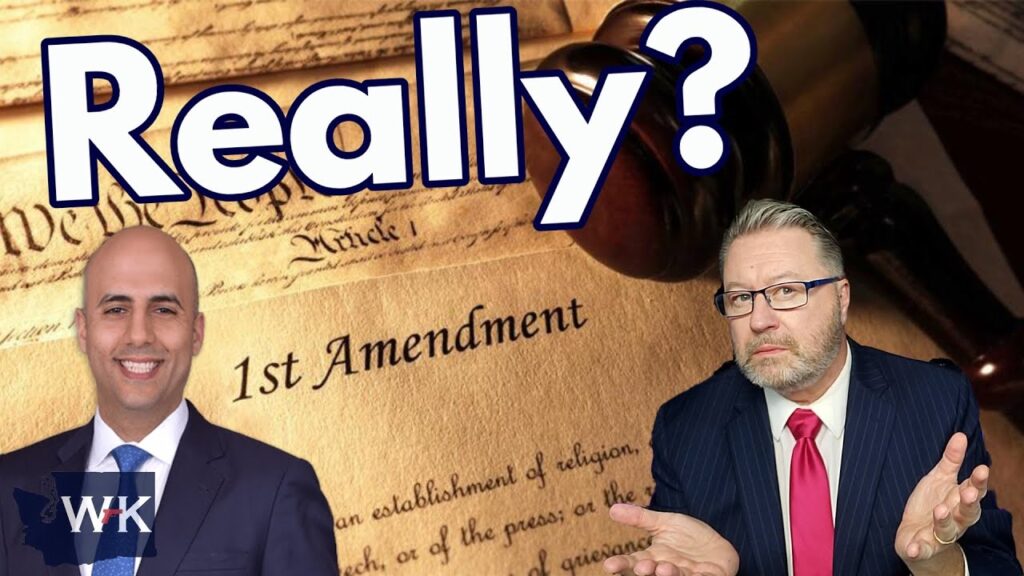 Two men in suits appear beneath large text saying "Really?" A gavel and a section of the U.S. Constitution showing "1st Amendment" are in the background. The man on the left smiles, and the man on the right gestures with a puzzled expression.