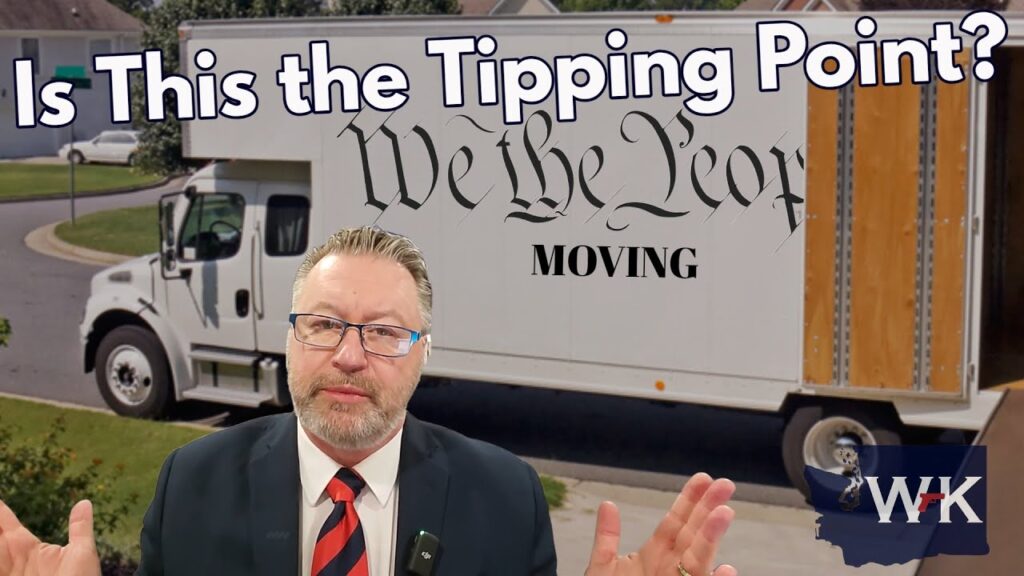 A man in a suit stands in front of a moving truck with "We the People" written on the side. The text "Is This the Tipping Point?" is displayed at the top. The background shows a suburban street.