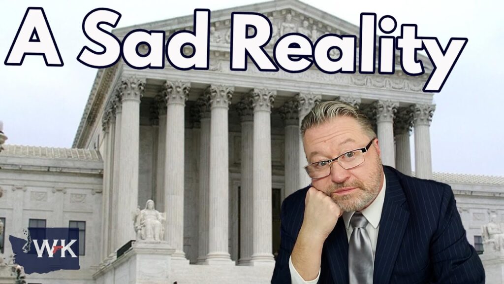 A man in a suit leans his head on his hand, looking contemplative, against a background of a large courthouse with columns. The words "A Sad Reality" are prominently displayed at the top.