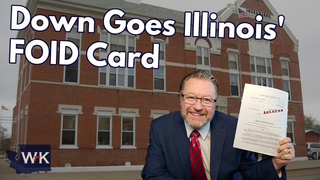 A man in a suit smiles and holds up a piece of paper in front of a large brick building. The text on the image reads, "Down Goes Illinois' FOID Card." A logo with "WK" is in the corner.