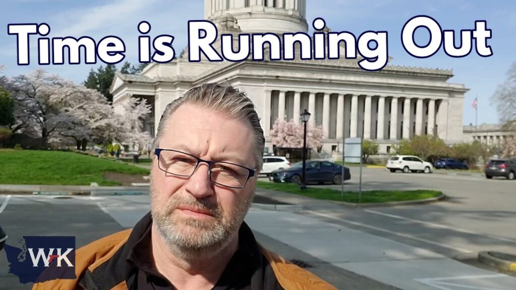 A man with glasses stands outside, with a large government building in the background. The text "Time is Running Out" is displayed at the top. Trees and cars can be seen around the building.