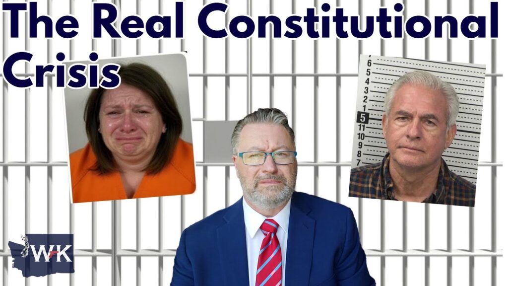 A man in a suit and red striped tie is centered in front of jail bars. To his left is a crying woman in an orange jumpsuit, and to his right is a man in a mugshot. Text above reads “The Real Constitutional Crisis.”.