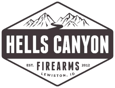 Logo featuring a diamond shape with mountain and river silhouettes. Text reads "Hells Canyon" prominently, with "Est. 2012," "Firearms," and "Lewiston, ID" below.