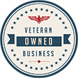 Circular emblem with an eagle design at the top. Text in the center reads "Veteran Owned Business" in blue and red. The border features blue stars.