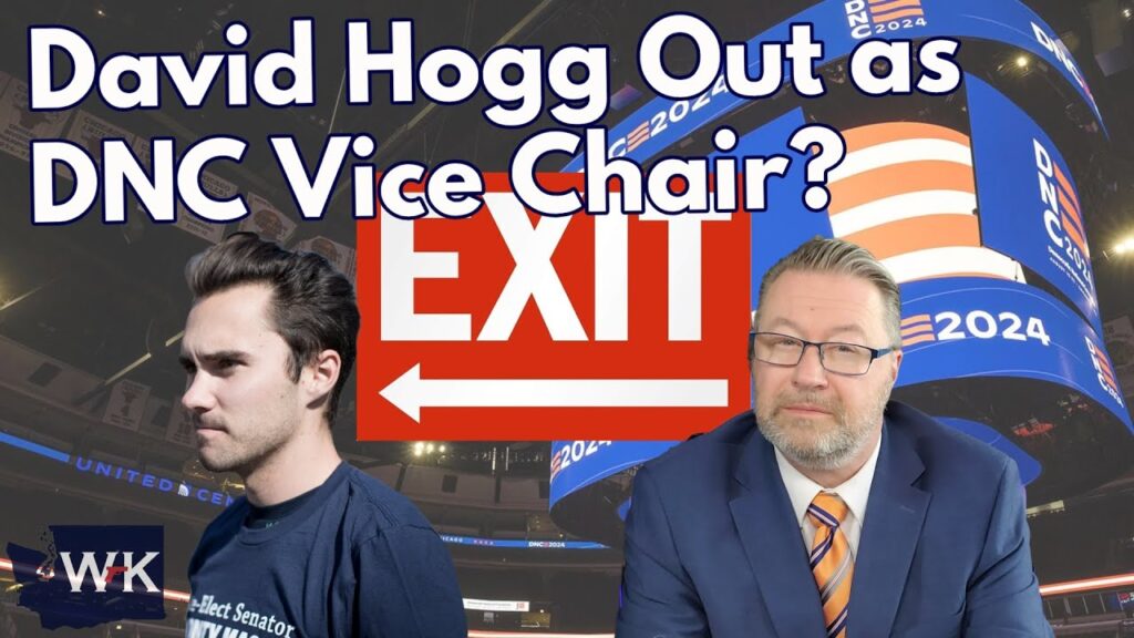 A man in a T-shirt stands next to a man in a suit and glasses in front of a large “EXIT” sign and a U.S. flag-themed screen. The text reads: “David Hogg Out as DNC Vice Chair?”.