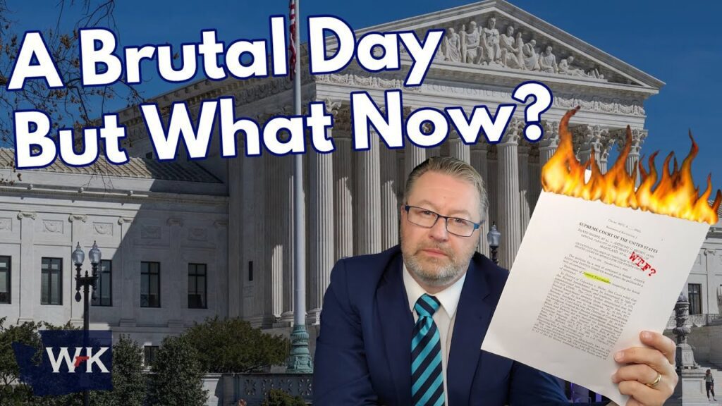 A man in a suit holds a burning document in front of the U.S. Supreme Court building. Large text reads, "A Brutal Day But What Now?" The atmosphere is tense and dramatic.