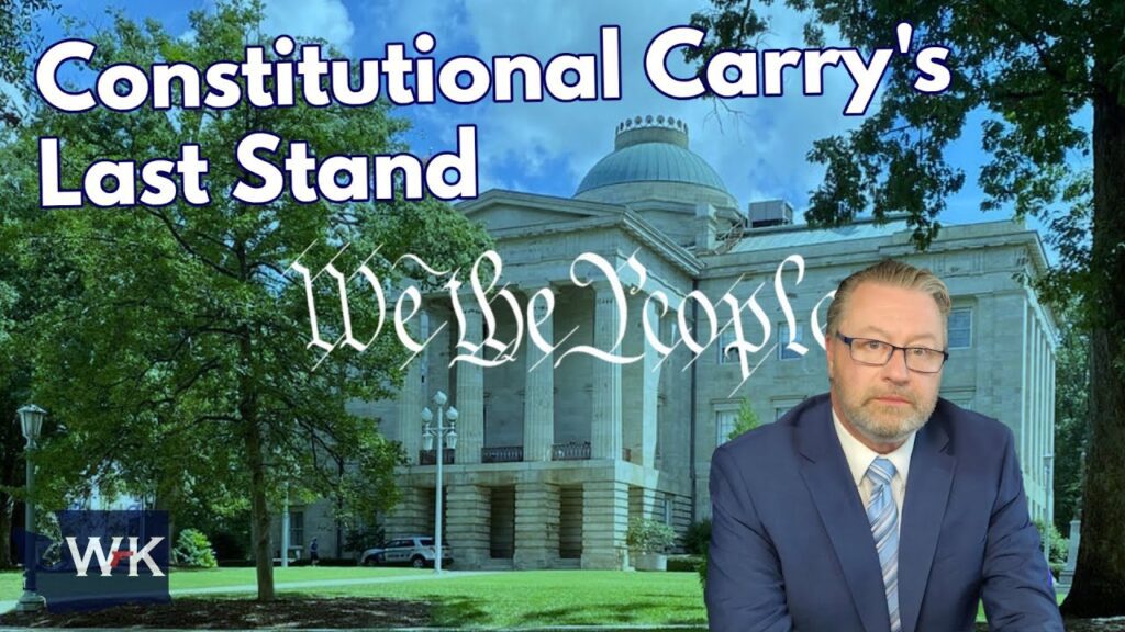 A man in a suit sits in front of a courthouse with trees. Overlaid text reads “Constitutional Carry’s Last Stand” and “We the People” in script. The lower left corner has a small blue box labeled “WK.”.