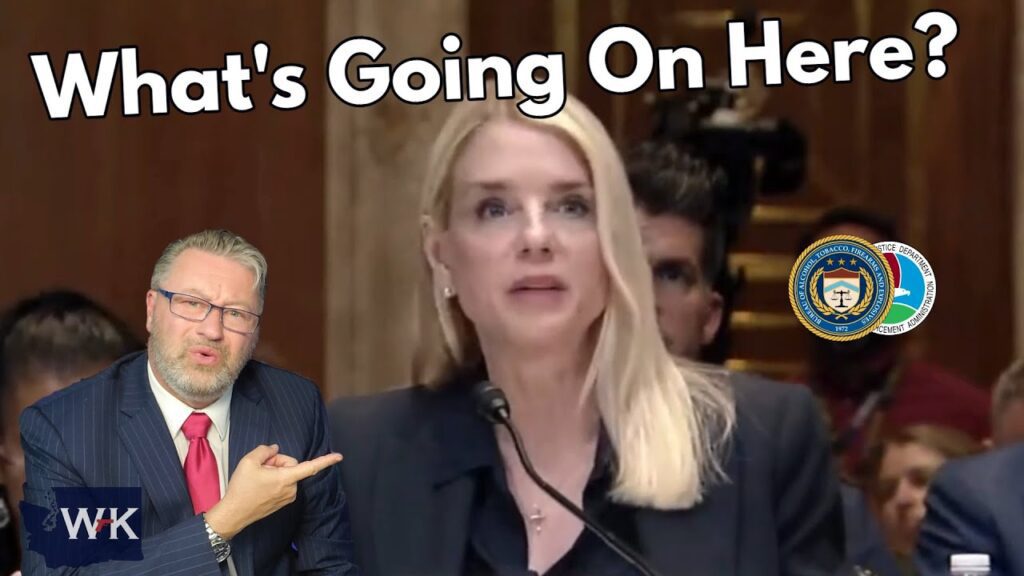 A woman speaks at a formal hearing while a man in a suit gestures incredulously in the foreground. Large text reads "What's Going On Here?" with official seals visible in the background.