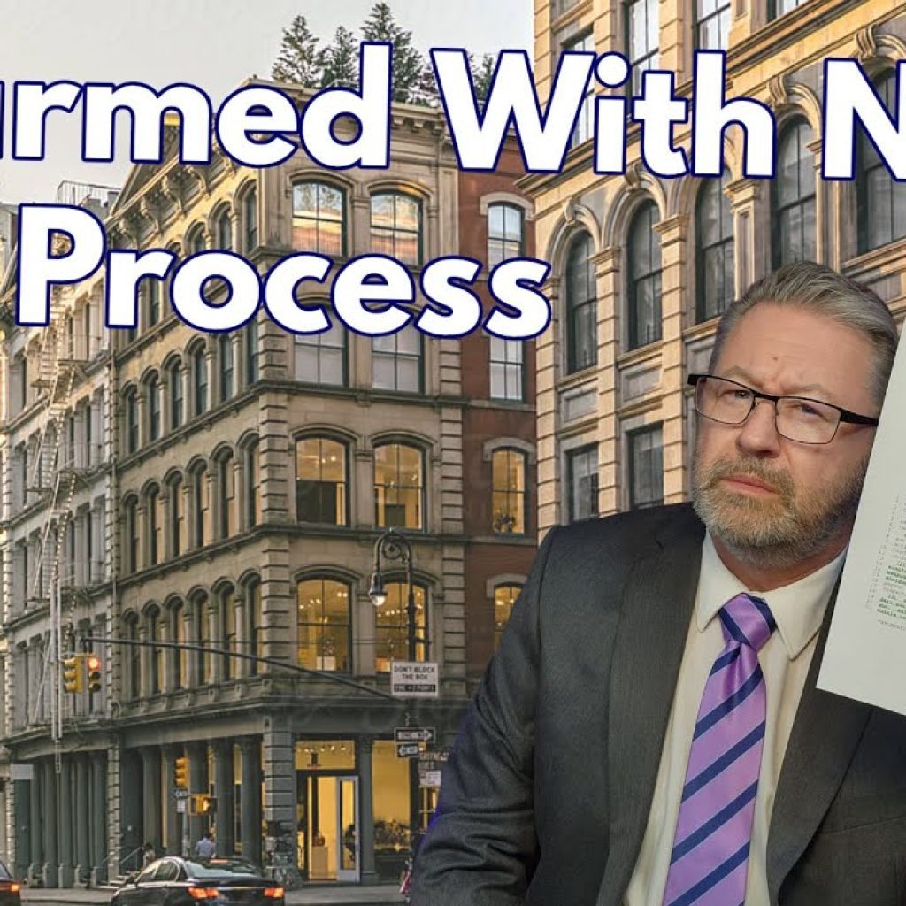 A man in a suit and glasses holds up a document while sitting in front of city buildings. Large text reads: "Disarmed With NO Due Process." The WK logo is in the bottom left corner.