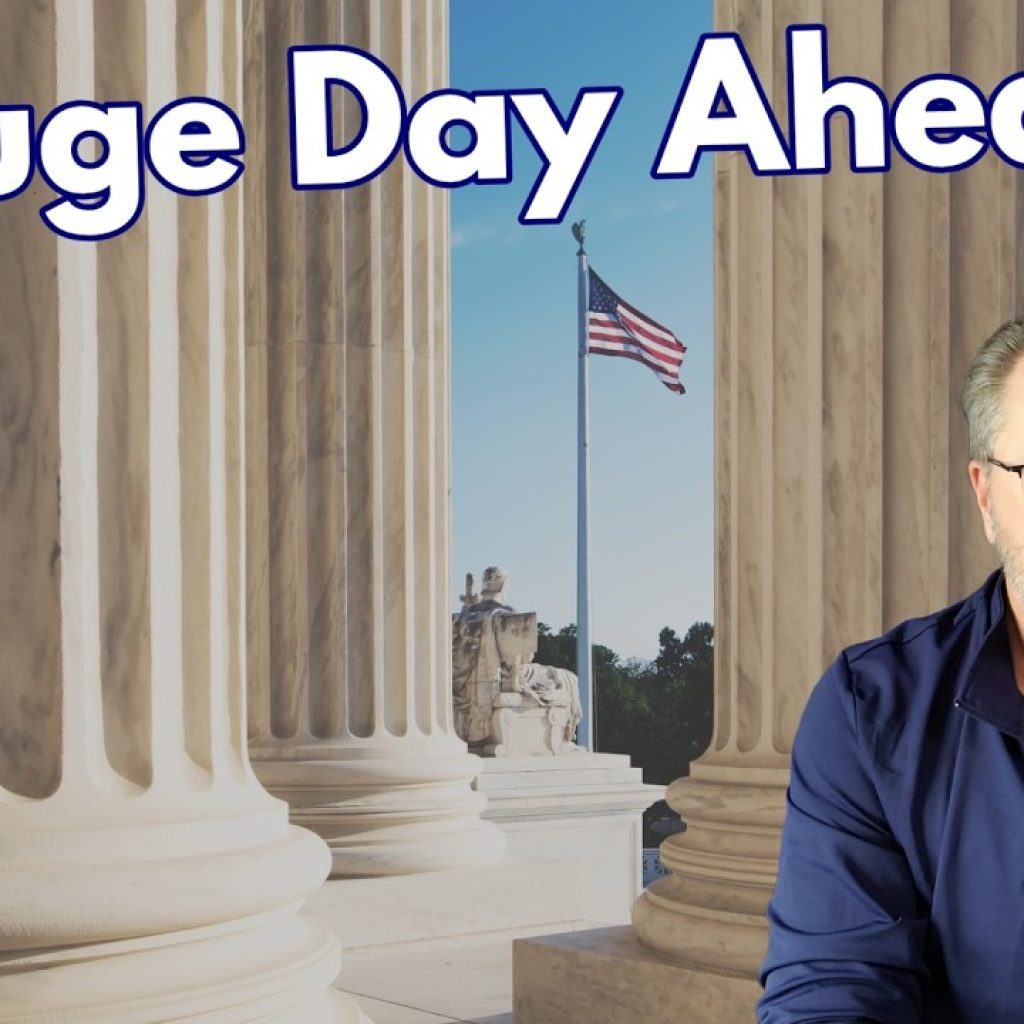 A man with glasses and a beard sits in front of large courthouse columns and an American flag, with the text "A Huge Day Ahead" above him and a "WK" logo in the bottom left corner.